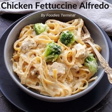 chicken fettuccine alfredo with broccoli in a grey bowl with a fork