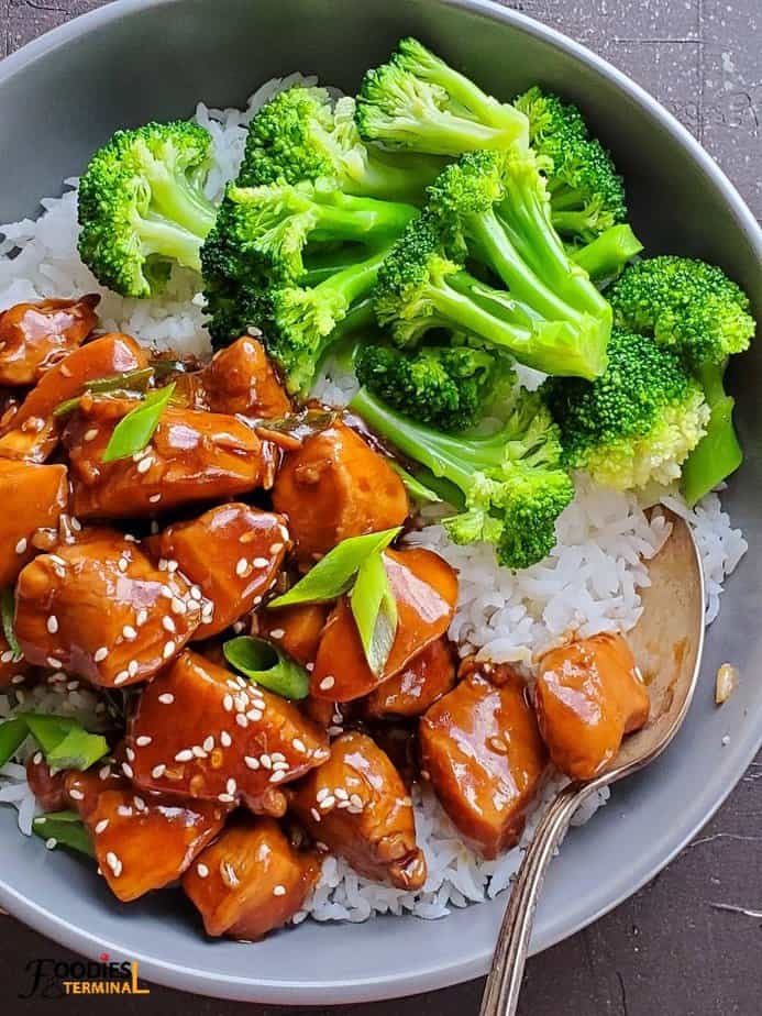 Instant Pot chicken teriyaki served in a grey bowl over rice with steamed broccoli florets on the side
