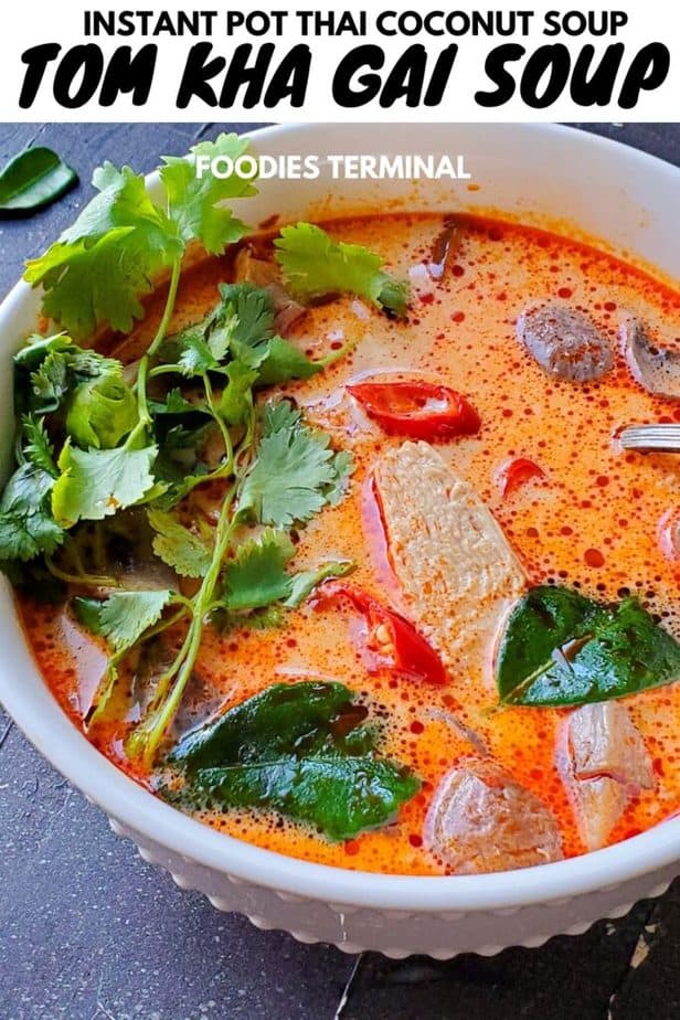 tom kha gai soup or thai coconut chicken soup in a white bowl garnished with Thai chilies & cilantro