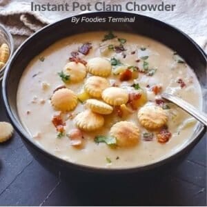 Clam Chowder topped with oyster crackers in a black bowl with a spoon