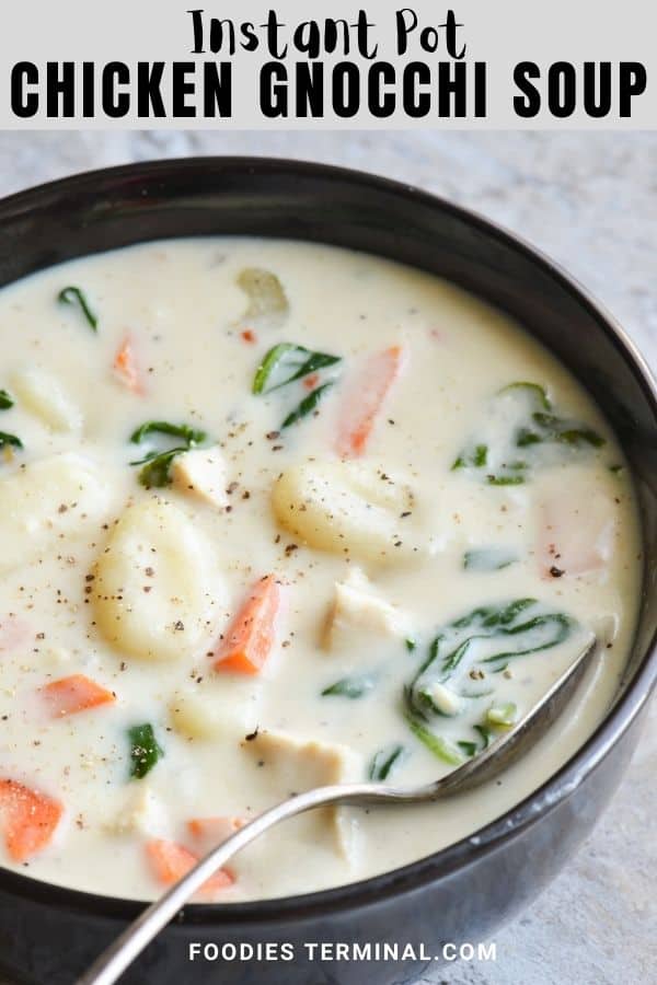 creamy chicken gnocchi soup in a black bowl with spoon 