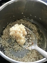 sateed arborio rice in a ladle