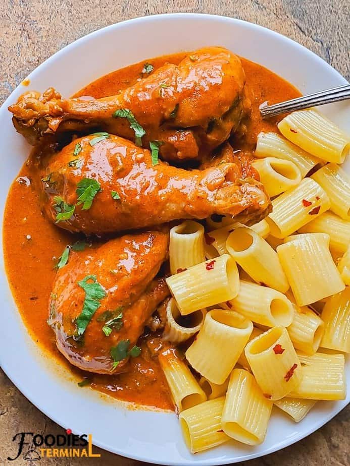 Instant pot chicken paprikash on a white plate with buttered rigatoni by a side