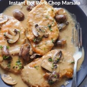 Instant pot pork chop marsala served in a black plate with a fork on the side