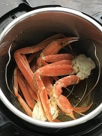snow crab legs inside instant pot on the metal trivet