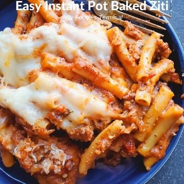 baked ziti on a blue plate with a fork on the side