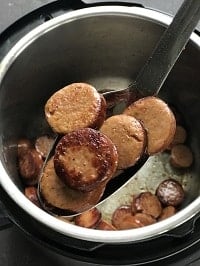 browned sausages in a ladle
