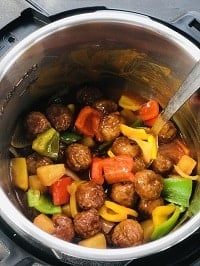 instant pot sweet and sour meatballs in instant pot with a steel ladle