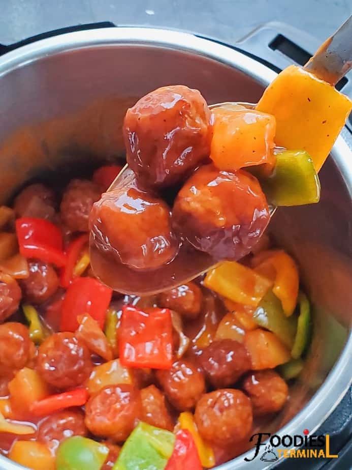 sweet and sour meatballs instant pot recipe made with frozen meatballs and pineapple scooped in a ladle