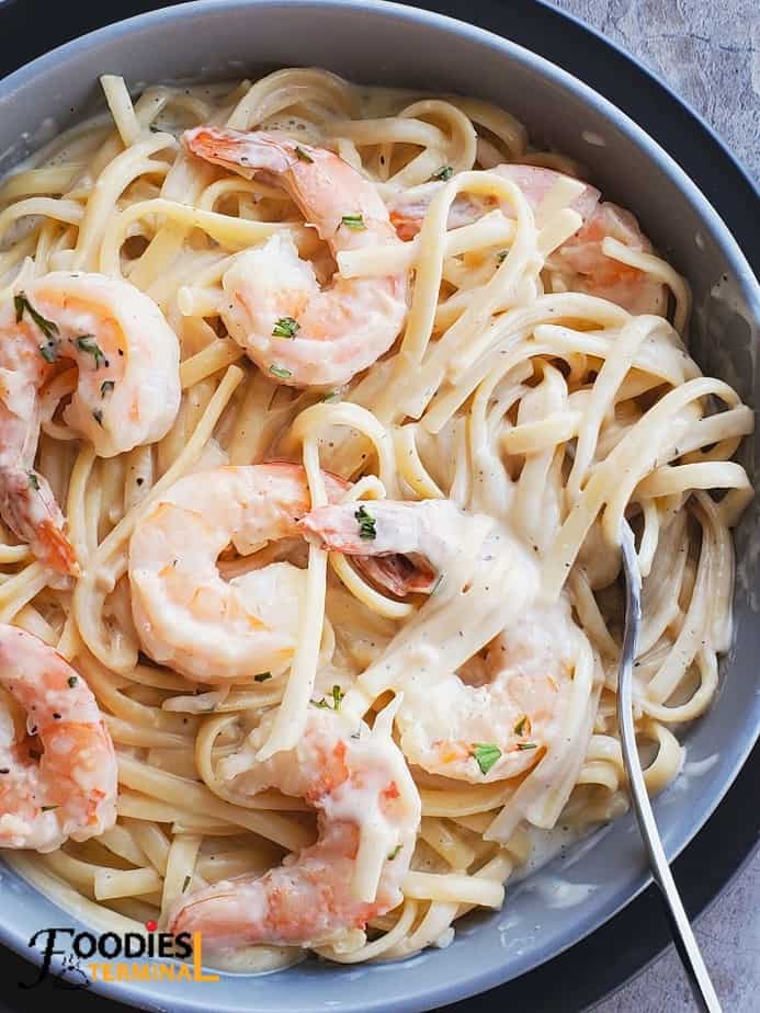 easy instant pot shrimp alfredo in a grey bowl with a spoon