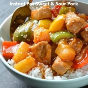 instant pot sweet and sour pork on a bed of rice served in light blue bowl with a spoon