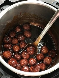 bbq meatballs in instant pot with a steel ladle