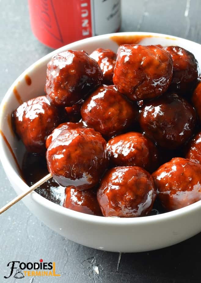 instant pot bbq meatballs with grape jelly served in a white bowl with a tooth pick