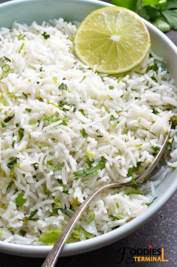 best pressure cooker cilantro lime rice in a light blue plate with a silver spoon and lime