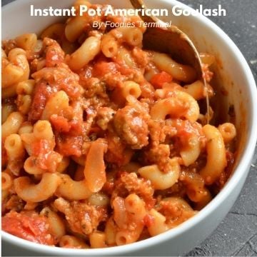 american goulash in a white bowl with a spoon