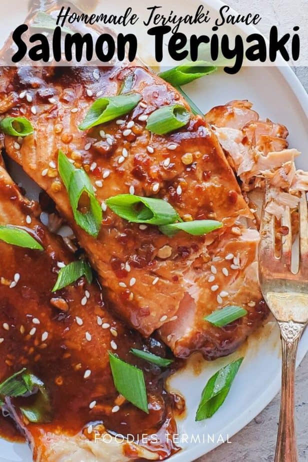 salmon teriyaki fillets on a white plate with a fork and garnished with white sesame seeds and scallions