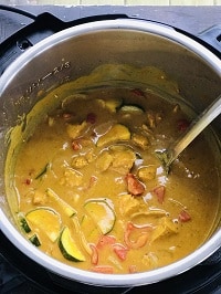 Thai peanut chicken curry in instant pot with a steel ladle