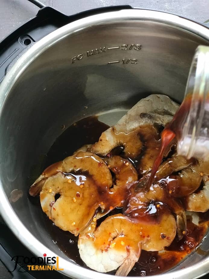 pouring best ever homemade stir fry sauce over frozen shrimp in instant pot