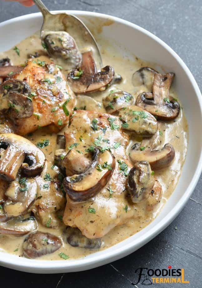 instant pot creamy chicken in a white bowl with a spoon