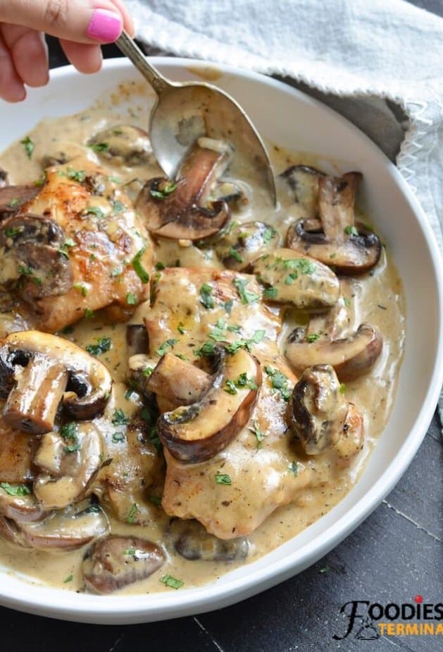 instant pot creamy chicken thighs in a garlic parmesan mushroom sauce in a white plate