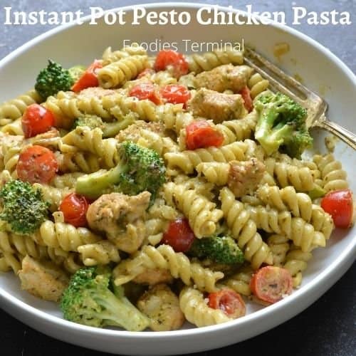 Instant pot pesto chicken pasta in a white bowl with a silver fork