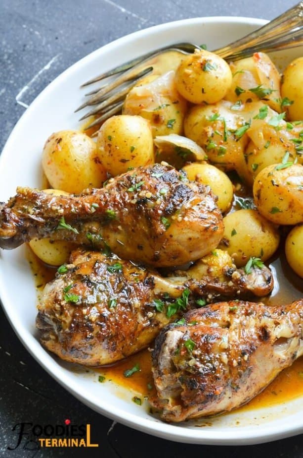 instant pot chicken drumsticks and potatoes served in a white plate with a pair of fork