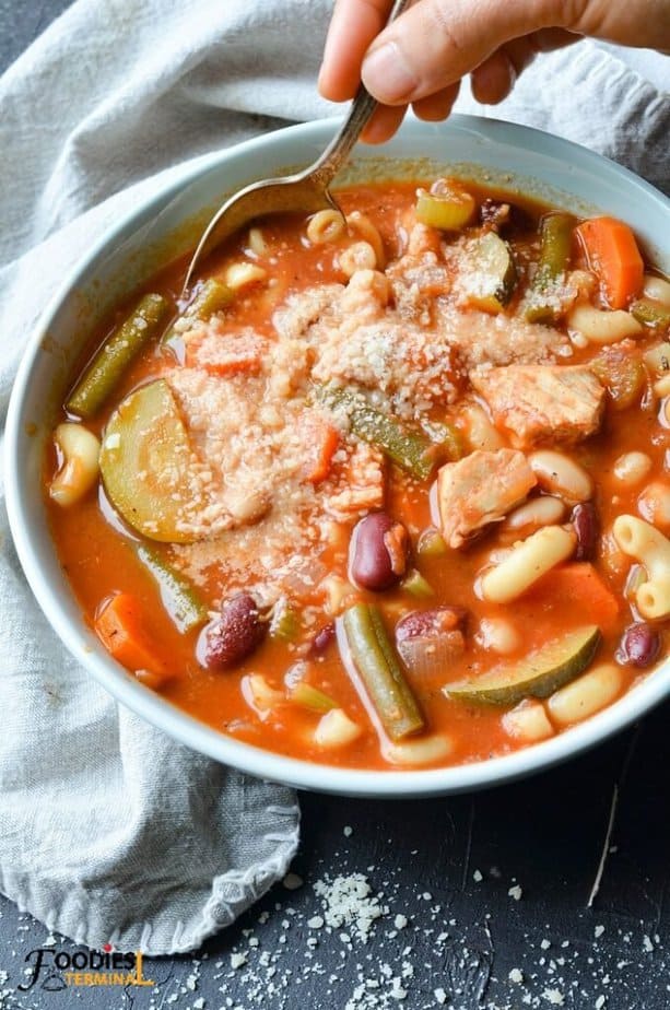 Healthy Chicken Minestrone Soup in a bowl served with grated parmesan cheese & a spoon