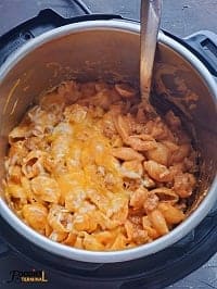 cheesy ground turkey pasta in instant pot with a steel ladle