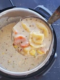 creamy chicken tortellini soup scooped in a ladle from the instant pto
