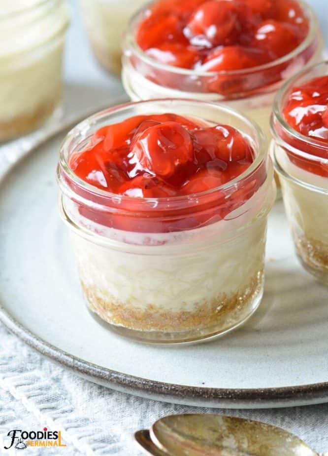 mason jar cheesecake topped with cherry pie filling