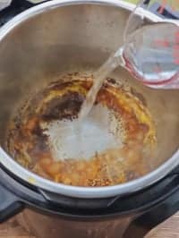 pouring water to deglaze pot
