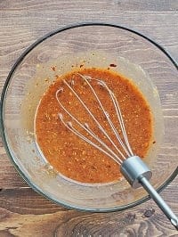 honey mustard sauce in a clear bowl with a whisk