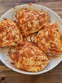 seasoned frozen chicken thighs on a white plate