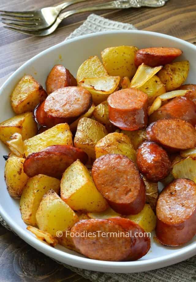air fryer sausage and potatoes in a white plate with a pair of forks in the background