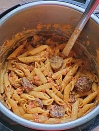 creamy cajun chicken pasta in instant pot with a steel ladle