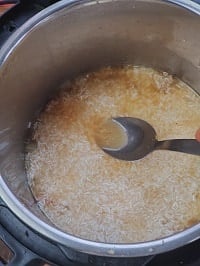 spreading rice with the help of a steel ladle