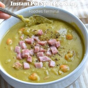 instant pot split pea soup in a white bowl with a spoon & garnished with diced ham