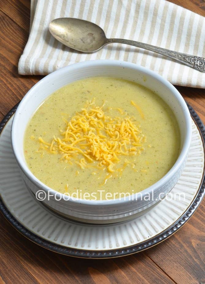 creamy zucchini soup instant pot recipe in a white bowl garnished with shredded cheddar cheese