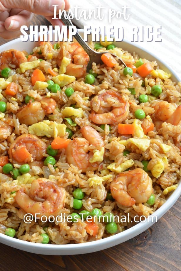 homemade shrimp fried rice being lifted with a spoon from a white plate