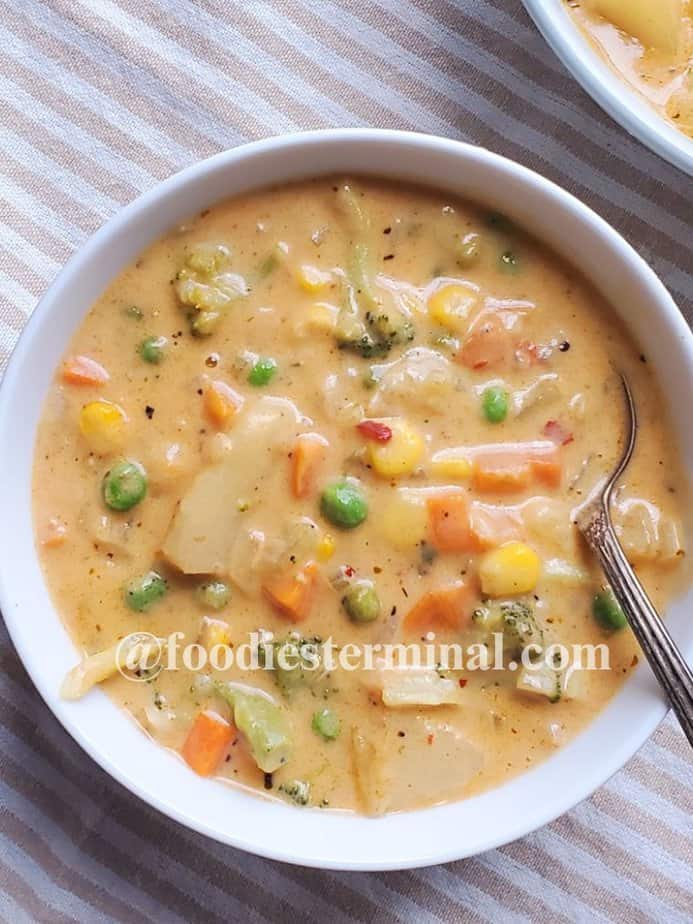 easy creamy vegetable soup in a white bowl with a spoon