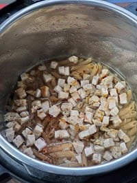 whole wheat pasta in instant pot layered with turkey cubes on top